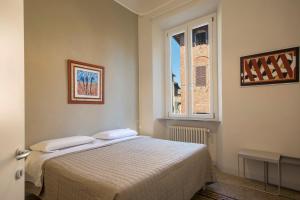 1 dormitorio con cama y ventana en Regis Condo, en Siena