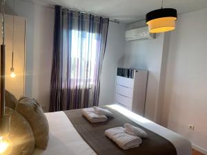1 dormitorio con 2 toallas encima de la cama en AZ El Balcón de Torre Nueva 2 - Parking Gratuito, en Zaragoza
