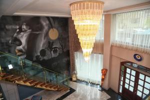 a hallway with chandeliers and a staircase in a building at Tuzla Garden Hotel & Spa in Tuzla