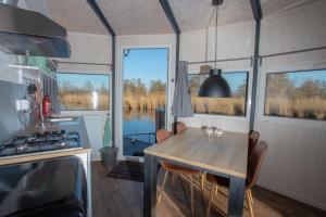 a kitchen with a table in a tiny house at Dobberhuisje in Nieuwkoop