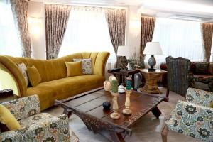 a living room with a yellow couch and a table at Tuzla Garden Hotel & Spa in Tuzla