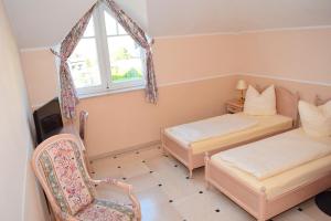 1 Schlafzimmer mit 2 Betten, einem Stuhl und einem Fenster in der Unterkunft Gästehaus Barese in Bad Münder am Deister