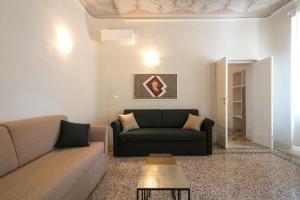 ein Wohnzimmer mit einem Sofa und einem Tisch in der Unterkunft Regis Condo in Siena