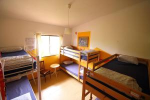 a room with four bunk beds and a window at Lagarto Hostel Tenerife in Valle de Guerra