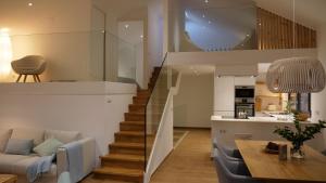 a living room with a staircase leading up to a kitchen at Casiñas Mariñeiras (Taberna Vella) in Portosin