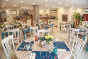 a restaurant with blue tables and white chairs at Tuzla Garden Hotel & Spa in Tuzla
