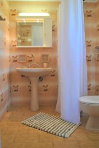 y baño con lavabo, aseo y espejo. en Lefkothea Apartments en Kassiopi