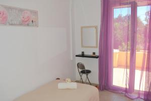 a bedroom with a bed and a window with purple curtains at Lefkothea Apartments in Kassiopi