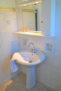 a white bathroom with a sink and a mirror at Lefkothea Apartments in Kassiopi