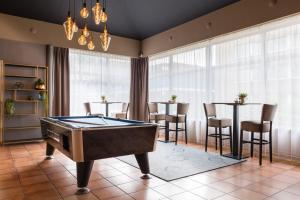 a billiard room with a table and chairs at New West Inn Amsterdam in Amsterdam