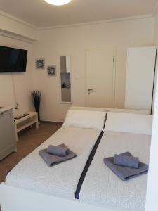 two beds in a room with towels on them at PortoBello in Portorož