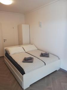 een bed in een kamer met twee schoenen erop bij PortoBello in Portorož