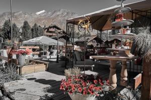 un patio con flores y mesas en Hotel Marmotte, en Saas-Fee