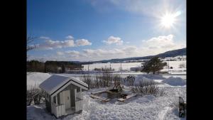 a small building in the snow with the sun behind it at Villa utanför Örnsköldsvik, Höga Kusten in Örnsköldsvik