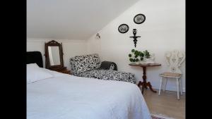 a bedroom with a bed and a chair and a mirror at Villa utanför Örnsköldsvik, Höga Kusten in Örnsköldsvik