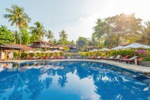 a swimming pool at a resort with chairs and umbrellas at Phu Quoc Eco Beach Resort in Phú Quốc