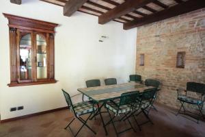 uma mesa e cadeiras num quarto com uma parede de tijolos em Villa Santa Maria em Montegiorgio