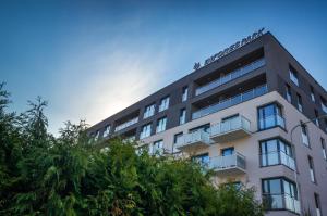 an apartment building with trees in the foreground at Apartamenty i Pokoje InforesPark in Przemyśl
