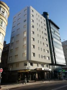 a large white building on the corner of a street at Hotel Maycar in A Coruña