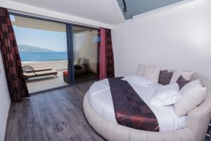 1 dormitorio con cama, sofá y balcón en Hotel Picasso, en Vlorë
