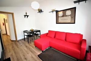 un sofá rojo en una sala de estar con mesa en Terraços de Elvas I, en Elvas