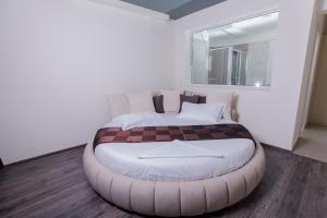 a bedroom with a large bed with a large ottoman at Hotel Picasso in Vlorë