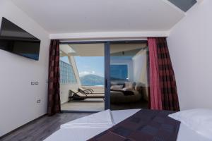 1 dormitorio con 1 cama y balcón con vistas. en Hotel Picasso, en Vlorë