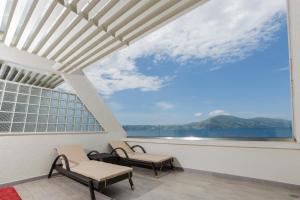 einen Balkon mit 2 Stühlen und Blick auf das Wasser in der Unterkunft Hotel Picasso in Vlorë