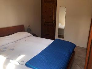 ein Schlafzimmer mit einem Bett mit einer blauen Decke darauf in der Unterkunft La Dimora di Cesare in Fano