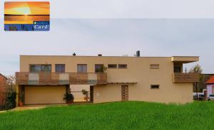 a house with a green lawn in front of it at Pannonia Appartements in Neusiedl am See