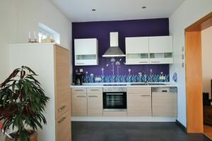 una cocina con una pared morada en Fewo Spiaggia - Gästehaus Kön, en Zeltingen-Rachtig