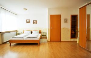 Un dormitorio con una cama y suelo de madera. en Fewo Spiaggia - Gästehaus Kön, en Zeltingen-Rachtig