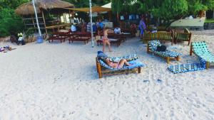 a group of people laying on chairs on the beach at Casa Cabana Beach in Vilanculos