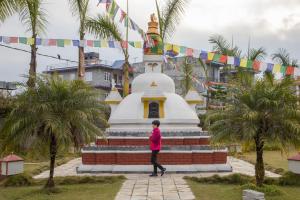 a person walking in front of a temple at Hotel Pokhara Grande in Pokhara