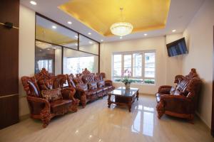 een woonkamer met lederen stoelen en een tafel bij Dragon King 1 Hotel in Da Lat