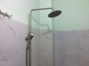 una doccia con porta in vetro in bagno di Khách sạn Ngọc Quỳnh a La Gi