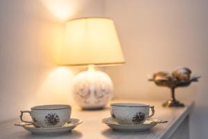 zwei Teetassen auf einem Tisch mit einer Lampe in der Unterkunft Al Bastione di Cagliari in Cagliari