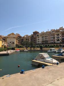 ein Boot, das an einem Dock in einem Fluss mit Gebäuden angedockt ist in der Unterkunft Sea view Port Saplaya Apartments,2 in Port Saplaya