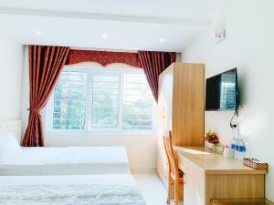 a hotel room with two beds and a window at Hoang Ngan 2 Hotel - TP. Vinh in Vinh