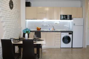 a kitchen with a table and a white refrigerator at сем. Павлови in Obzor