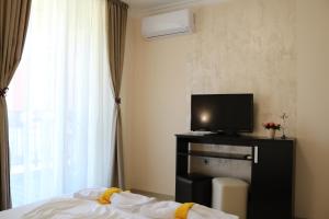 a hotel room with a bed and a television at сем. Павлови in Obzor