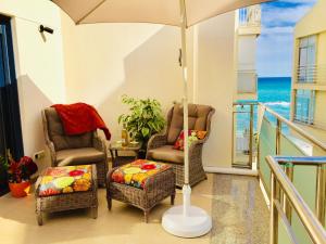 einen Balkon mit 2 Stühlen und einem Sonnenschirm in der Unterkunft Antares in Altea