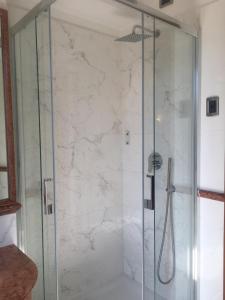 a bathroom with a shower with a glass door at Hotel Hiberia in Rome