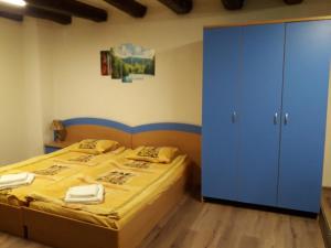 1 dormitorio con 1 cama y armario azul en Студио за четирима "Цвети", en Sapareva Banya