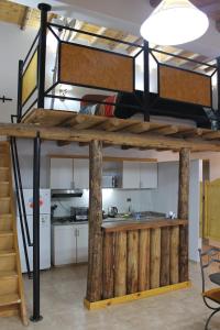 a loft bed in a room with a kitchen at Complejo Turistico Alfombra Magika in Mendoza