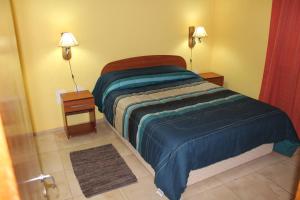 1 cama en una habitación con 2 mesitas de noche y 2 lámparas en Complejo Turistico Alfombra Magika en Mendoza