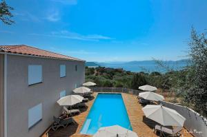 a swimming pool with umbrellas and chairs and a building at Résidence Giovanello in Porto Pollo