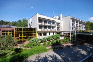un edificio con un jardín delante de él en Hotel Echo, en Cedzyna