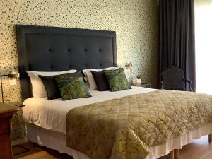 a bedroom with a large bed with green pillows at Hotel Diana in Vence