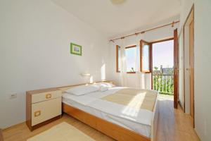Un dormitorio con una cama y una ventana grande. en Apartments Danijela Rab, en Rab 61 fotos más